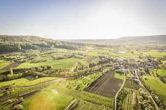 Aerial View of Green Rolling Hills and Village in Spring