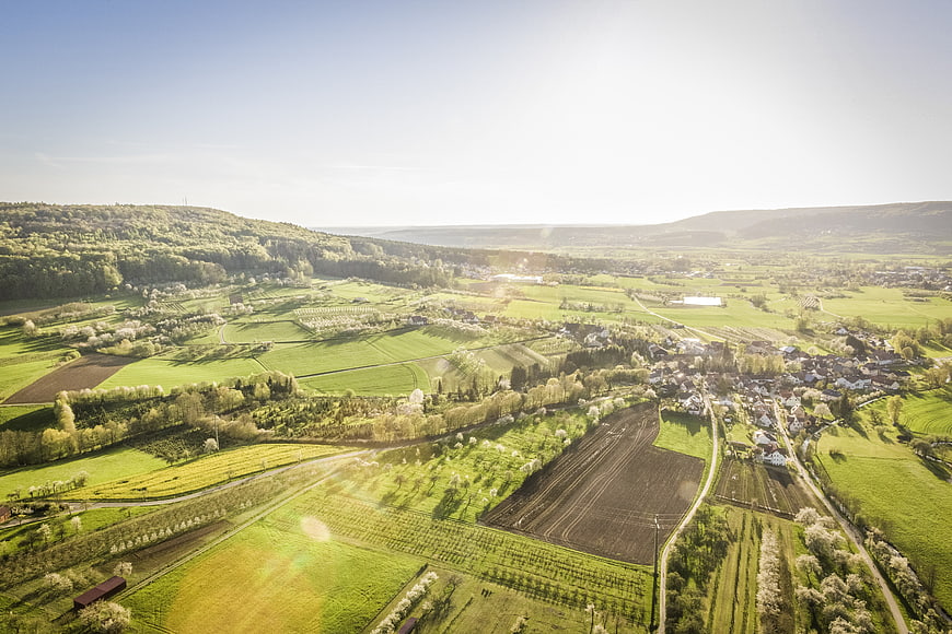 Aerial View of Green Rolling Hills and Village in Spring