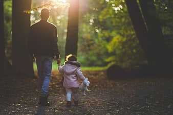 Father and Daughter Walking Hand in Hand in Forest