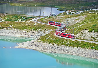 Red Rhaetian Railway Train Crossing Alpine Lakes at Bernina Pass