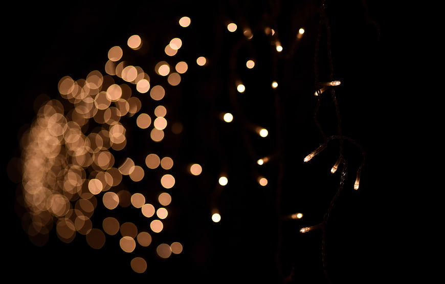 Warm bokeh lights on black background with depth of field