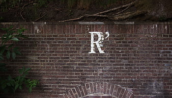 White Letter R Graffiti on Old Red Brick Wall