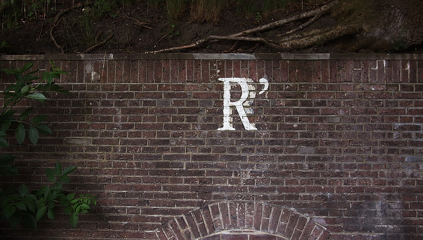 White Letter R Graffiti on Old Red Brick Wall
