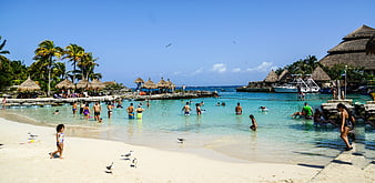 Tourists swimming in turquoise lagoon at Xcaret, Cancun, Mexico