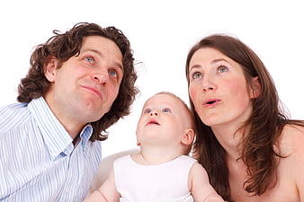 Family of three looking up with surprised expressions on white background