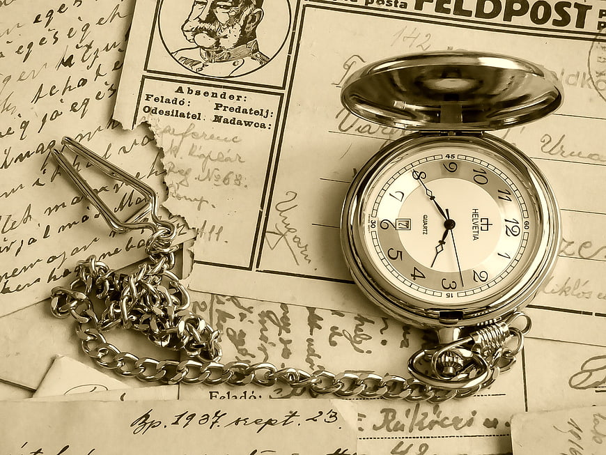 Vintage silver pocket watch on old handwritten letters