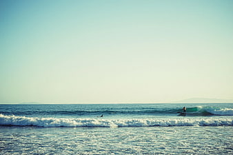 Surfer Riding Wave on Sunny Blue Ocean Day