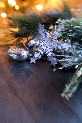 Silver Snowflake Ornament on Pine Branch with Bokeh Lights