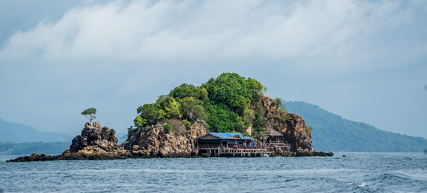 Tropical Island Landscape With Rocky Coastline And Wooden Pier