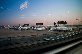 Airport tarmac with airplanes at sunset