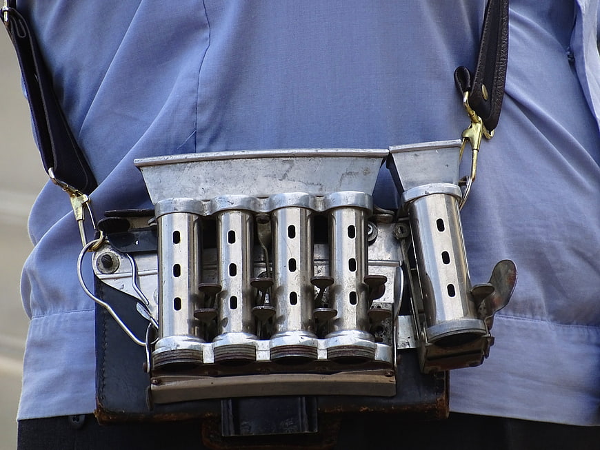 Vintage Metal Coin Dispenser on Blue Uniform