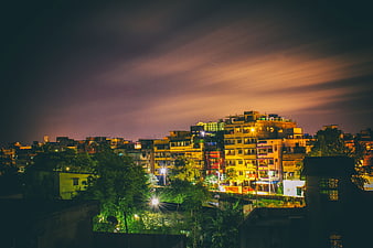 Night cityscape with colorful buildings and dramatic sky