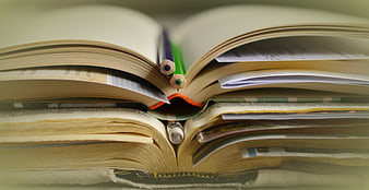 Stack of Open Books with Pencils and Notes