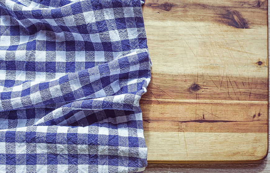 Blue and white checkered cloth on rustic wooden cutting board