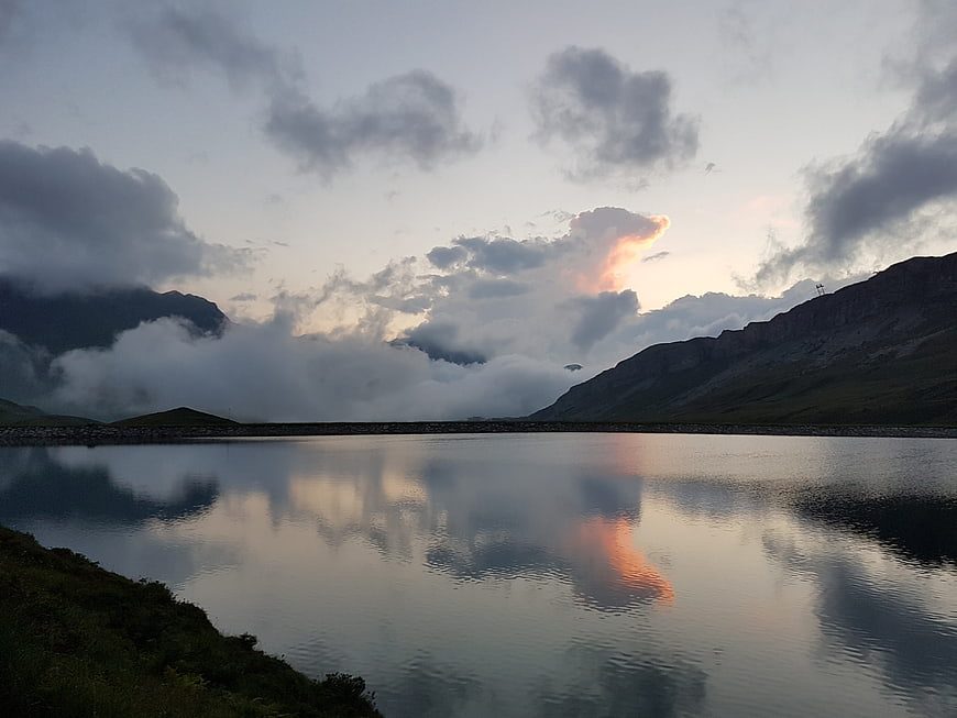 Serene Mountain Lake Reflection at Sunset with Dramatic Clouds