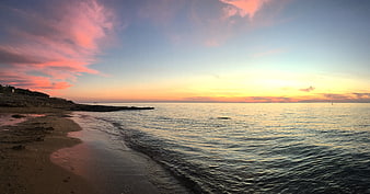 Serene Sunset Seascape with Pink Clouds and Sandy Beach