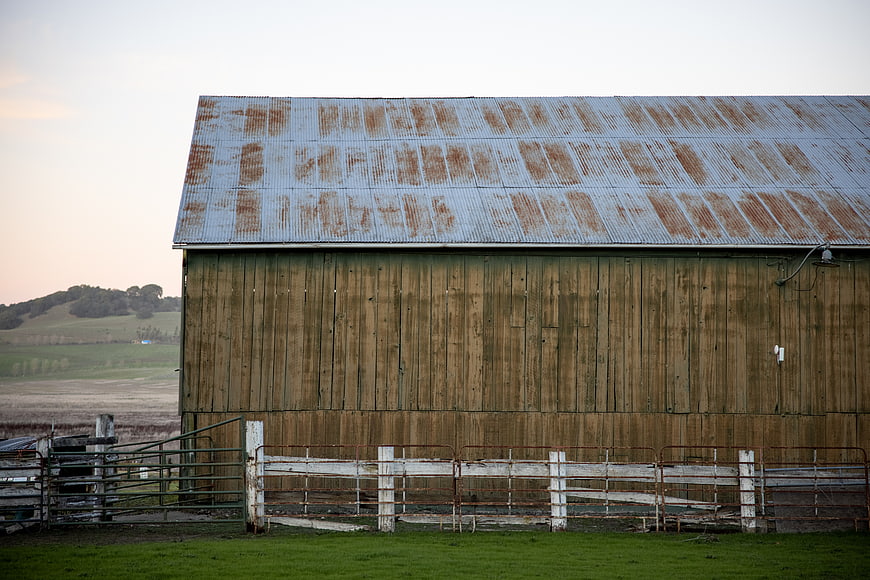 Weathered wooden barn with rusty corrugated metal roof