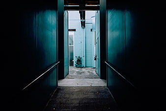 Dark Teal Alleyway Leading to Bright Courtyard
