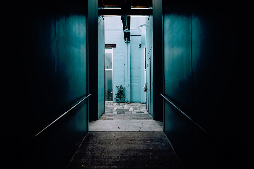 Dark Teal Alleyway Leading to Bright Courtyard
