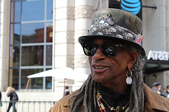 Portrait of man with dreadlocks and patterned hat in city
