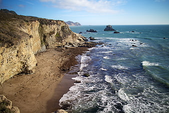Scenic coastal cliffs and sandy beach with ocean waves