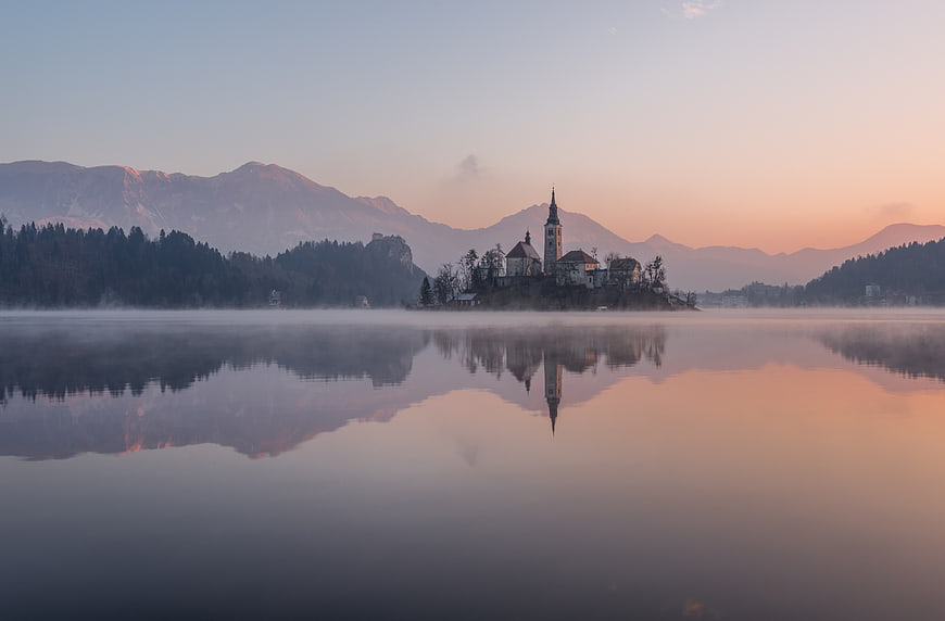 Serene Lake Bled Island Reflection at Sunrise with Mist