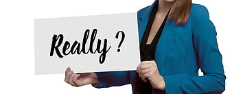 Businesswoman holding white sign with Really question mark text