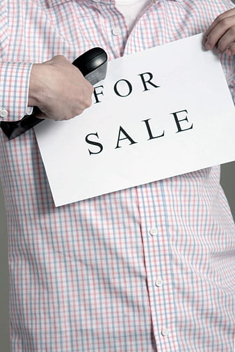 Man holding for sale sign with barcode scanner