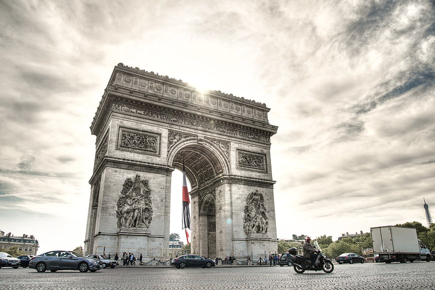Arc de Triomphe Paris with traffic and cloudy sky
