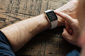 Man Using Smartwatch on Rustic Wooden Table