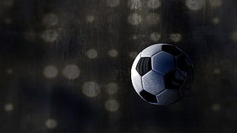 Soccer ball on dark textured background with bokeh