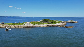Aerial View of Rocky Coastal Island with Blue Ocean