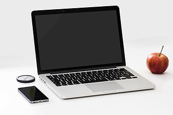 Laptop, smartphone, and apple on white background