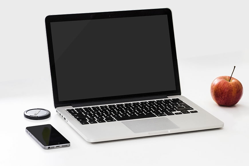 Laptop, smartphone, and apple on white background