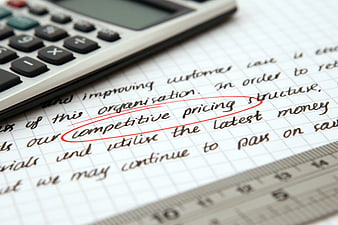 Competitive pricing handwritten text circled on paper with calculator