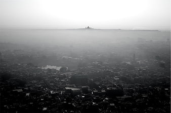Aerial black and white view of city skyline in thick fog