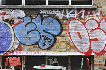 Colorful graffiti art on brick wall with cafe table