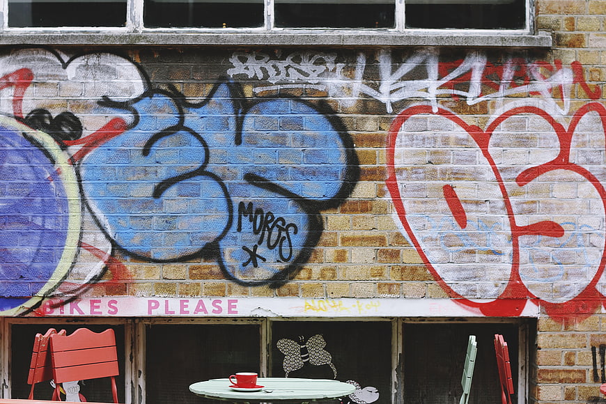 Colorful graffiti art on brick wall with cafe table