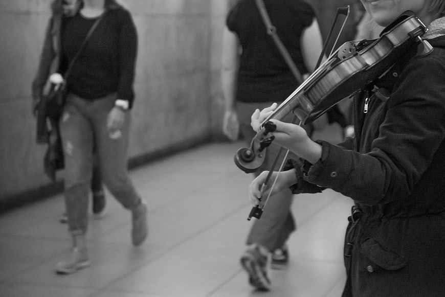 Street musician playing violin in subway station