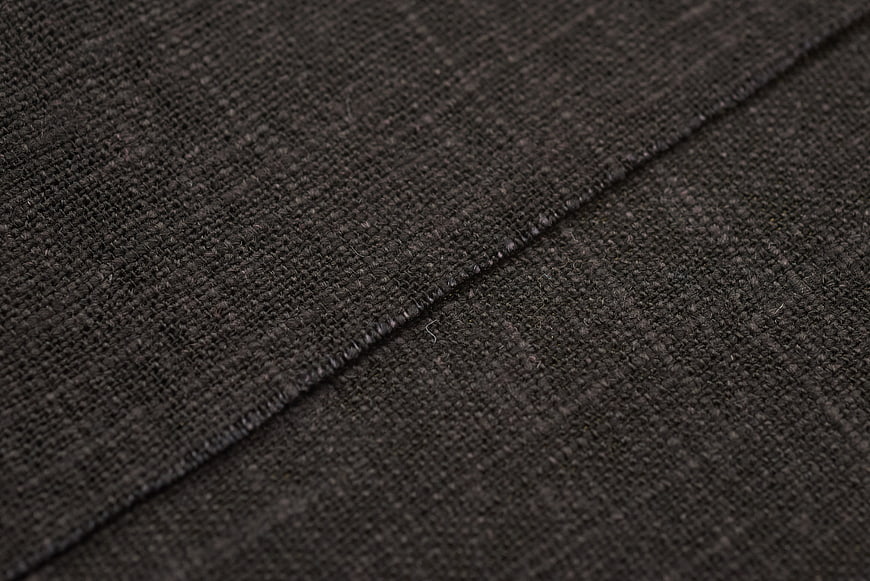 Close-up of dark gray woven fabric texture with stitching