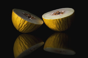 Sliced Yellow Melon on Black Background with Reflection