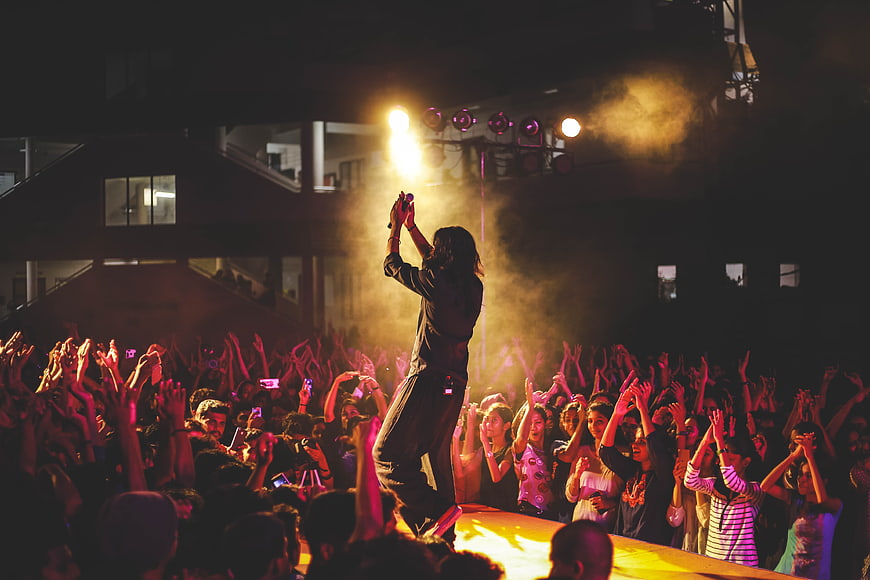 Live concert singer performing on stage with enthusiastic crowd