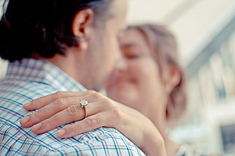 Romantic close-up of a couple embracing with a diamond engagement ring