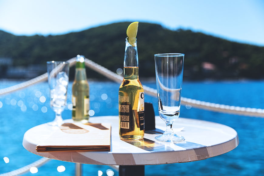 Summer drinks on a coastal table with a scenic ocean background