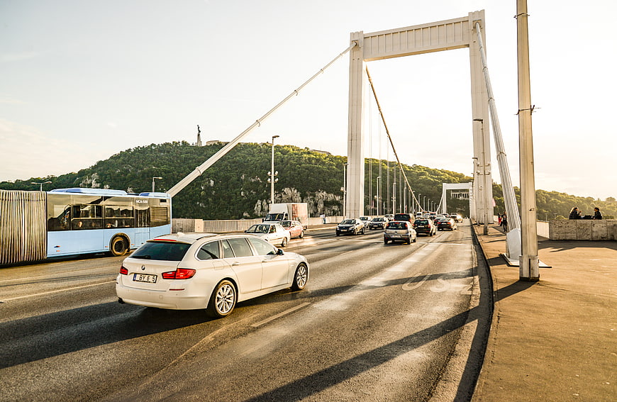 White car driving on Budapest bridge with traffic