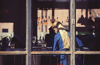 Blonde Woman Sitting Alone in Restaurant Window