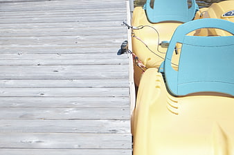 Yellow paddle boats docked at wooden pier