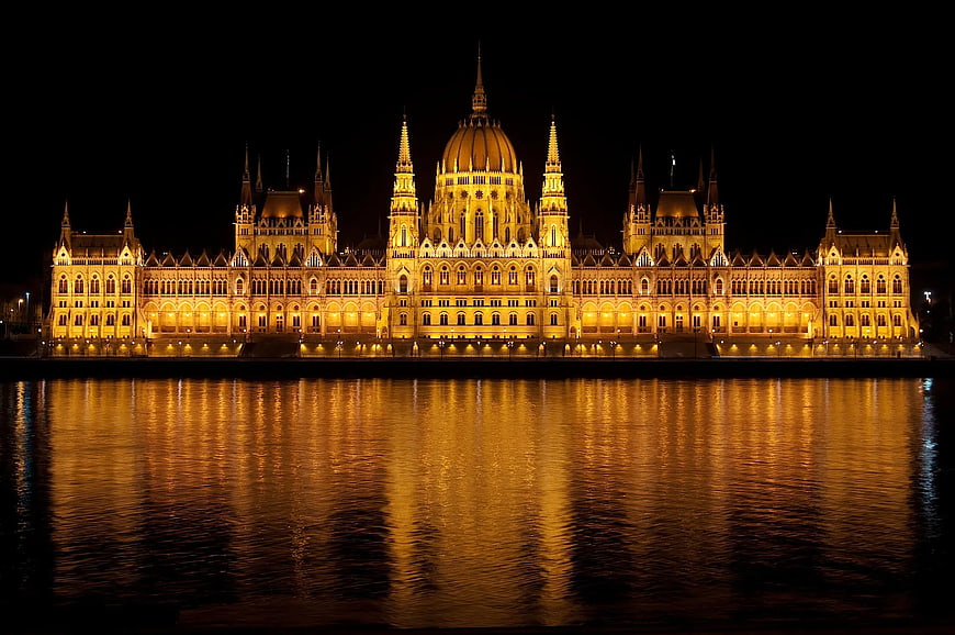 Hungarian Parliament Building illuminated at night with river reflection