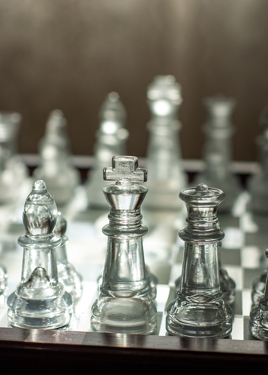 Glass Chess Pieces on Board with Shallow Depth of Field