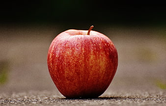 Close-up of Red Apple on Textured Pavement